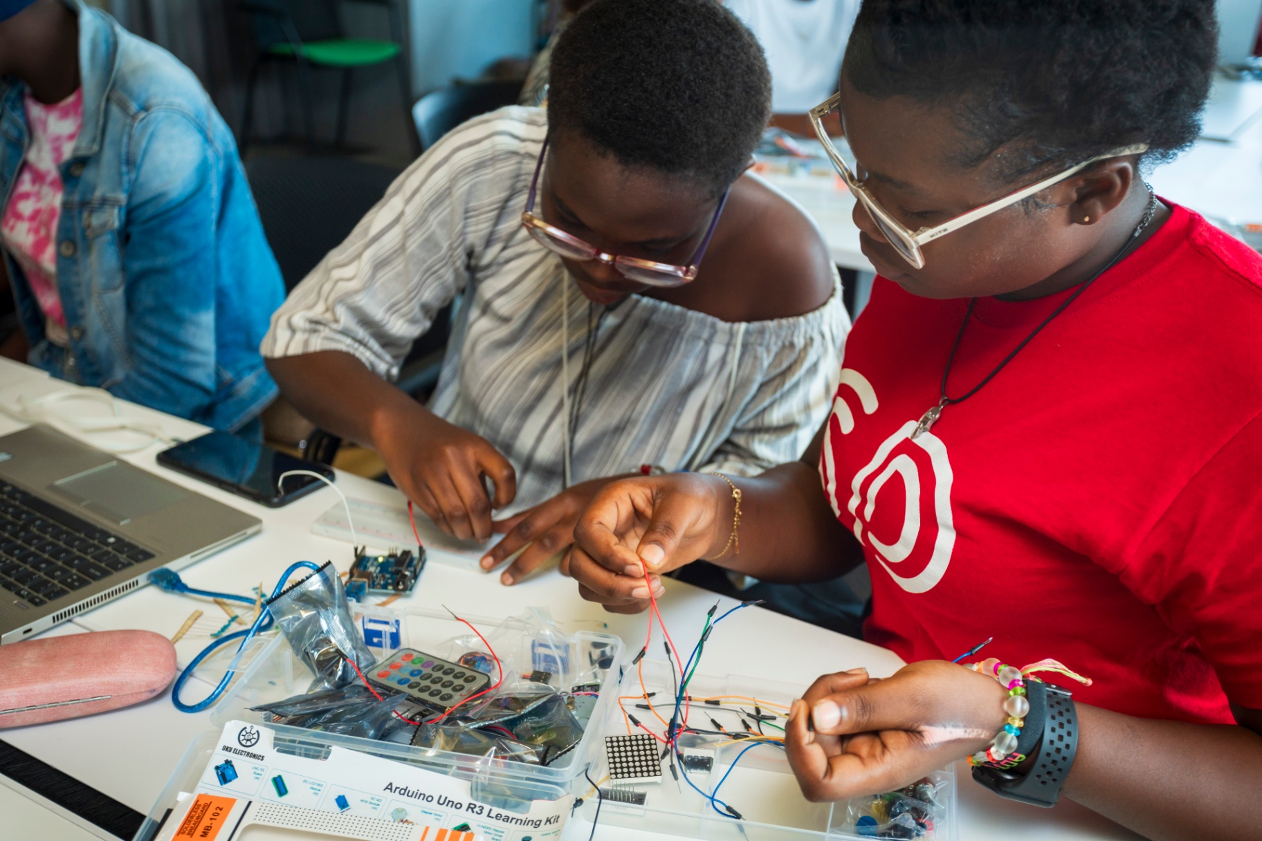 Students carefully wiring components on a breadboard