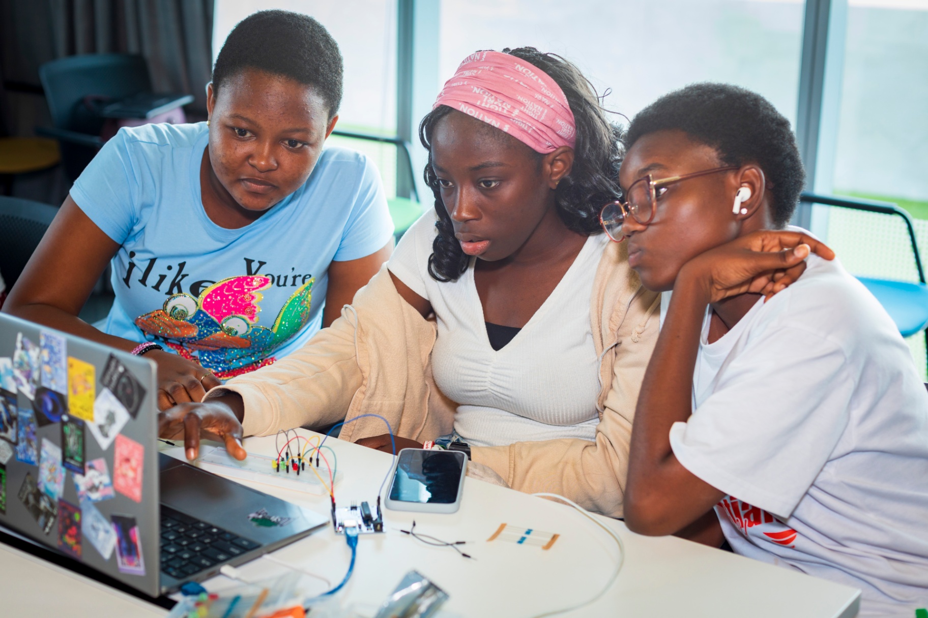 Trio of students reviewing their Arduino project on screen