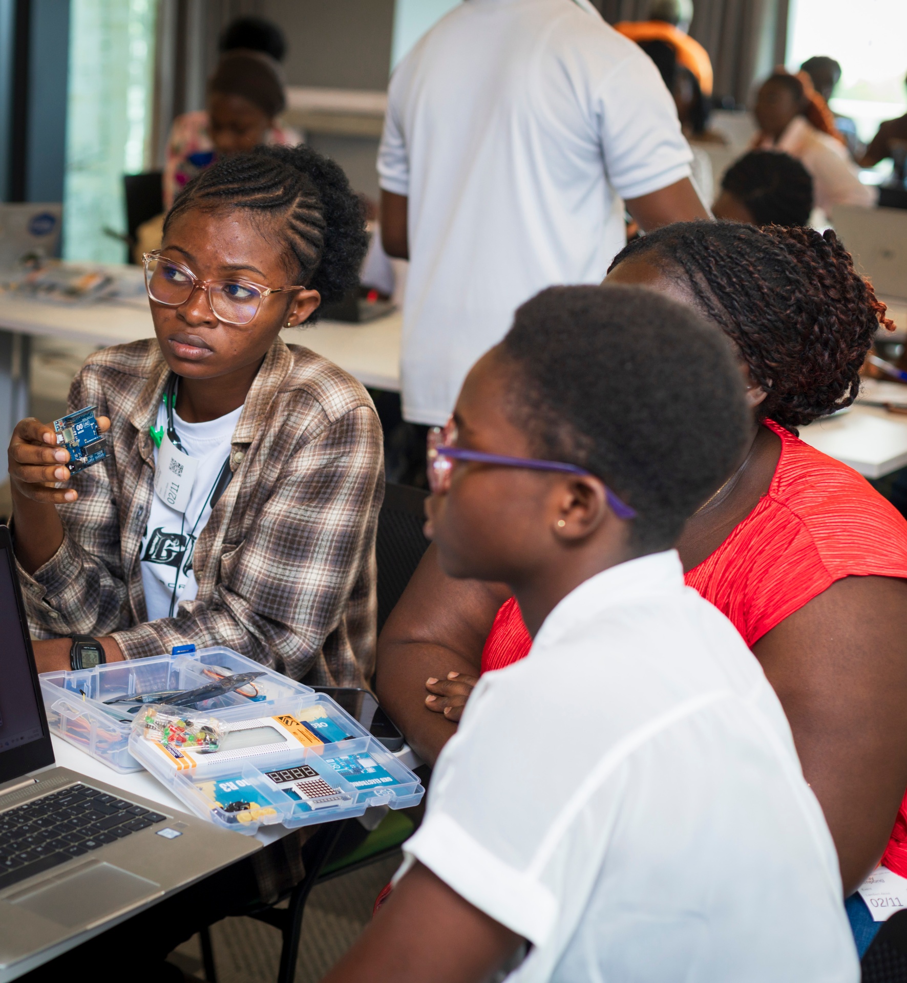 Student holding an Arduino board during the workshop