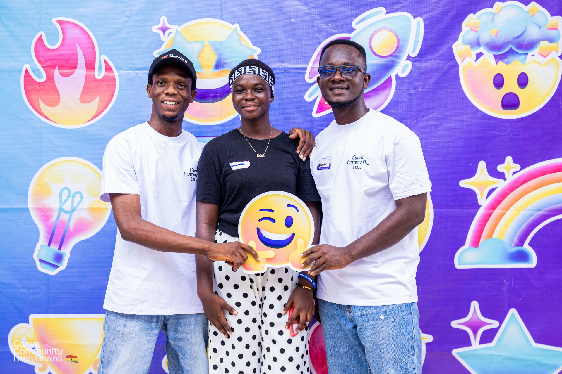 Students posing at a photo wall during a creative event