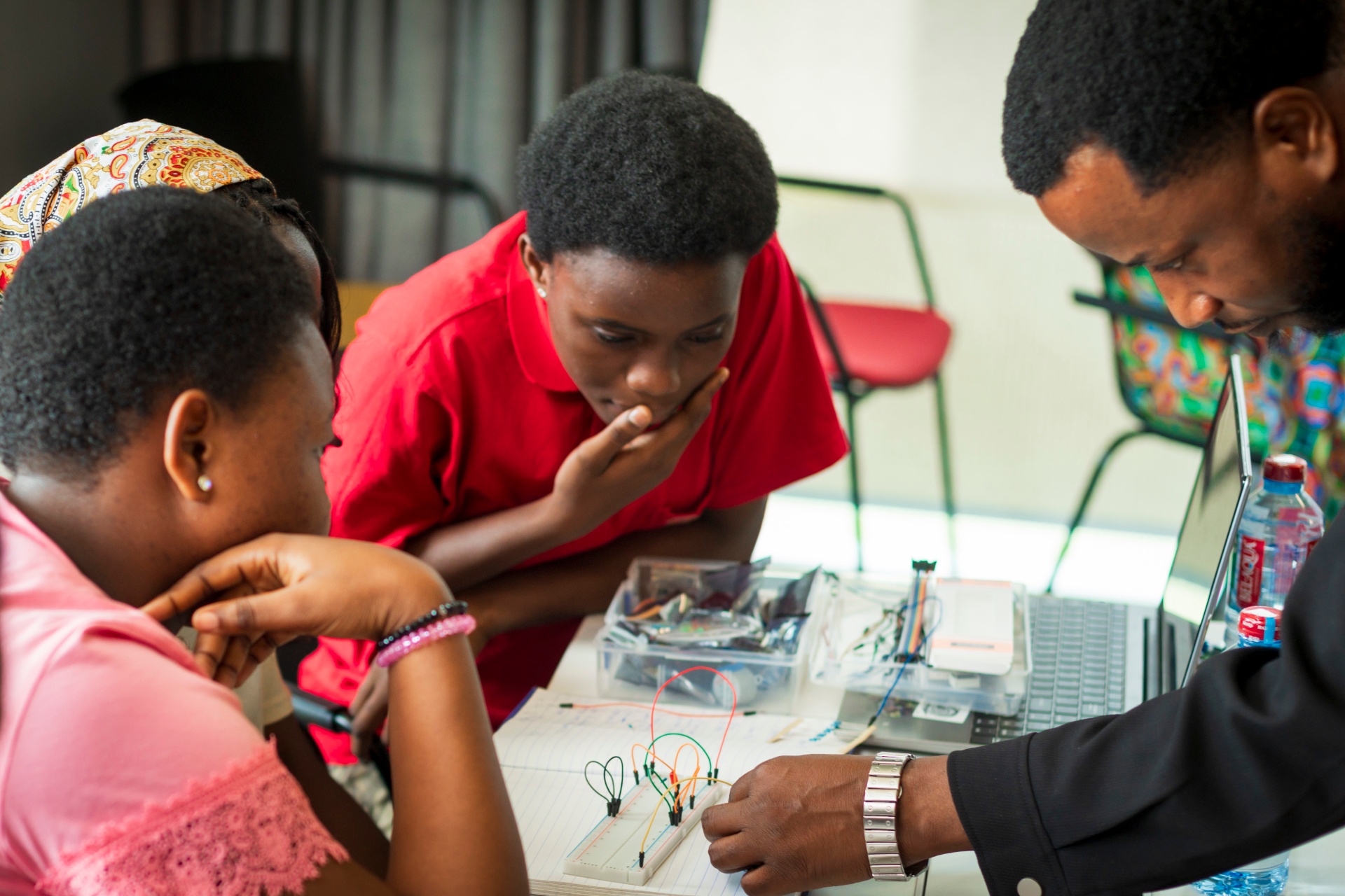 Facilitator guiding students through a breadboard circuit