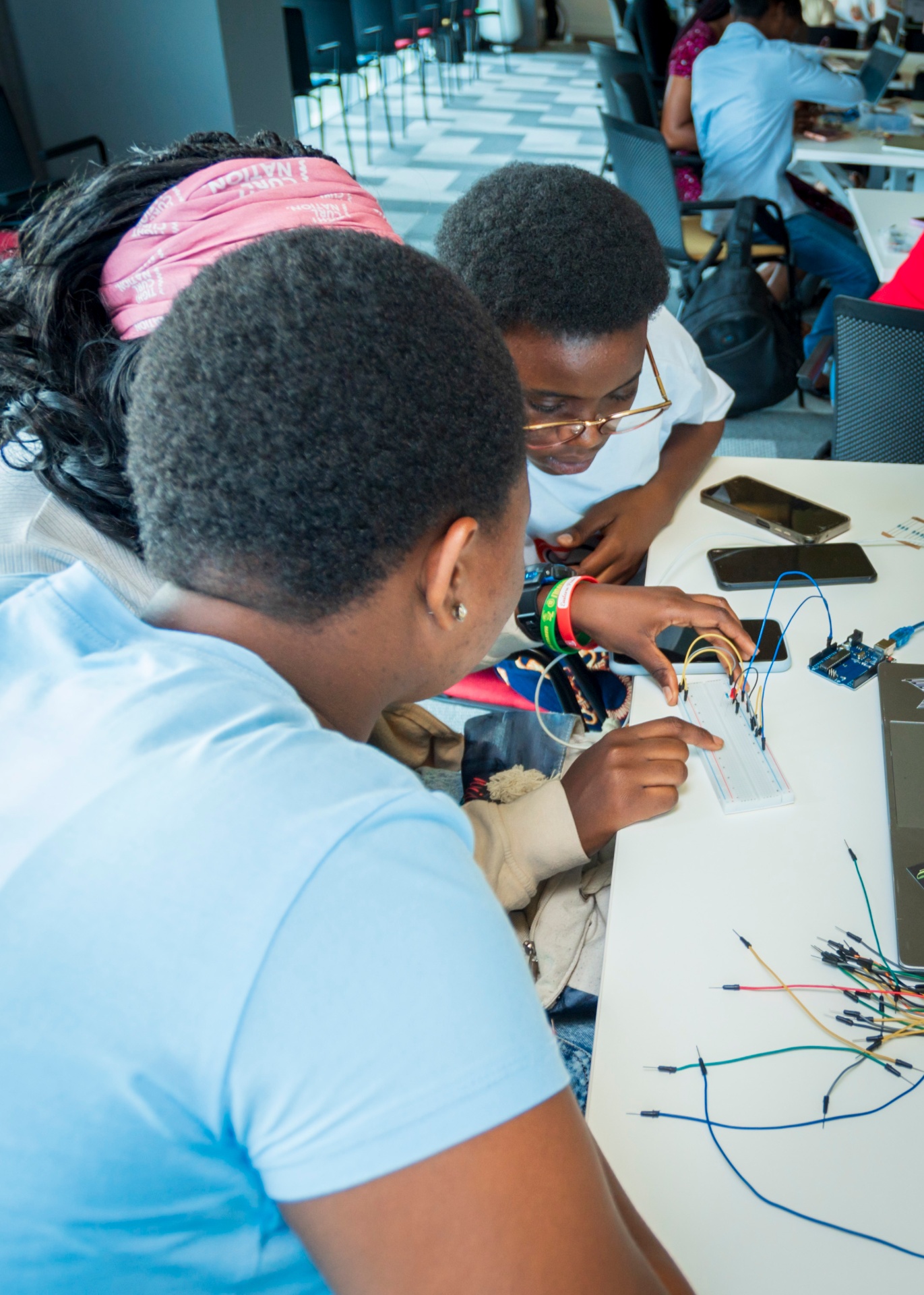 Students building a breadboard circuit up close