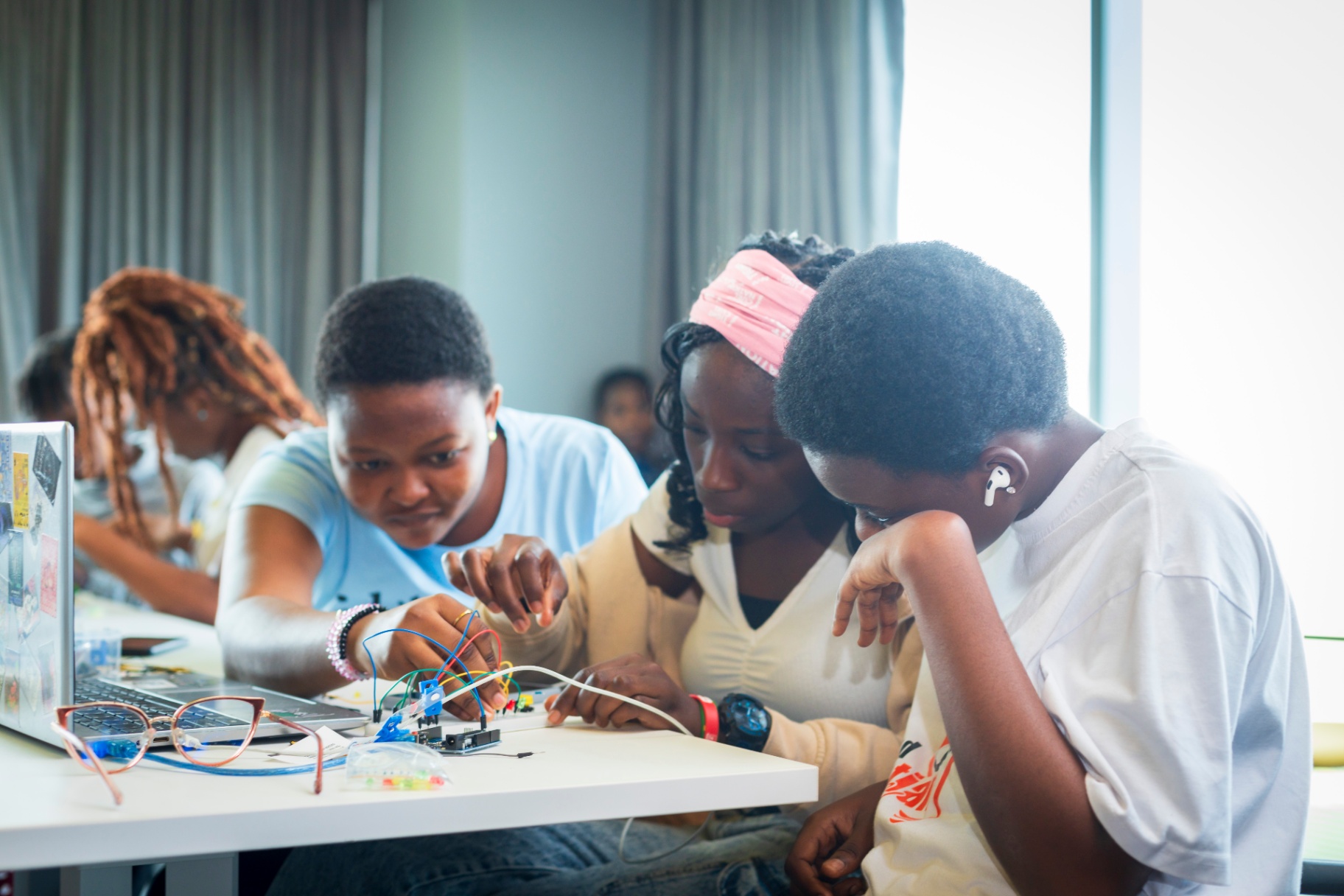 Hands-on teamwork wiring an Arduino circuit at the workshop