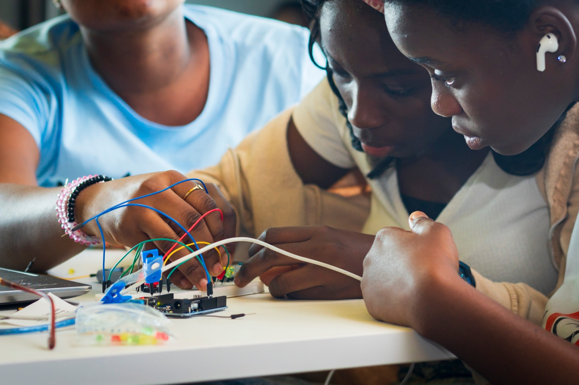 Close-up of students building a jumper-wire circuit on an Arduino Uno
