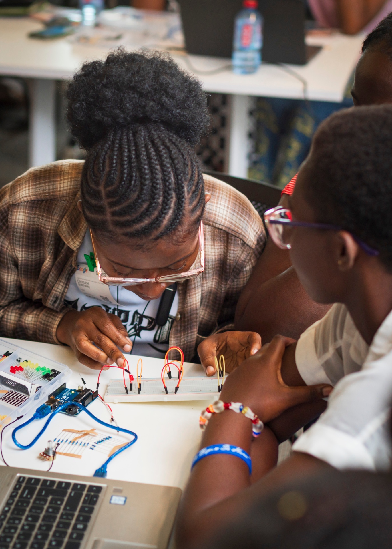Student focused on wiring an LED circuit on a breadboard